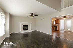 Kansas City house for rent - a living room with a fireplace and a ceiling fan