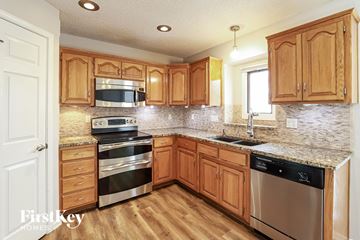 Kansas City house for rent - a kitchen with wooden cabinets and stainless steel appliances