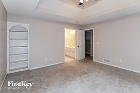 Kansas City house for rent - a master bedroom with a carpeted floor and a closet and a bathroom