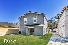 Jacksonville house for rent - a blue house with a driveway and a yard with grass