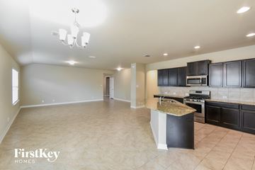 San Antonio house for rent - A kitchen with black cabinets and a granite countertop.