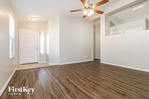 Surprise house for rent - A spacious room with a ceiling fan and wooden flooring.