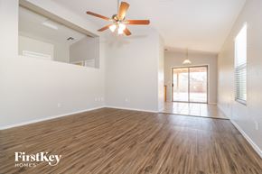 Surprise house for rent - A spacious room with wooden flooring and a ceiling fan.