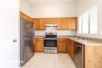 Surprise house for rent - A kitchen with wooden cabinets and stainless steel appliances.