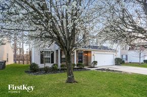 Kannapolis house for rent - A tree with white blossoms stands in front of a house.