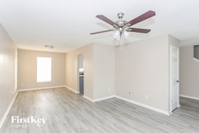Kannapolis house for rent - A spacious room with a ceiling fan and lighting fixture.