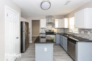 Kannapolis house for rent - A kitchen with a black countertop and stainless steel appliances.