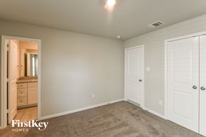 San Antonio house for rent - A bedroom with a carpeted floor and a white door.