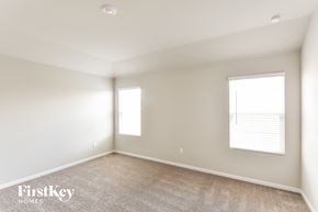 San Antonio house for rent - A spacious room with a carpeted floor and two windows.