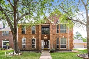 League City house for rent - a brick house with trees in front of it