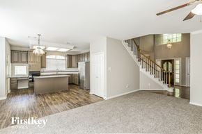 League City house for rent - an open kitchen and living room with a staircase and a kitchen island