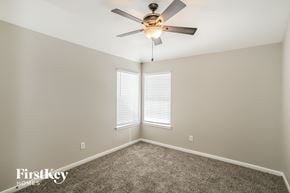 League City house for rent - a bedroom with a ceiling fan and a window