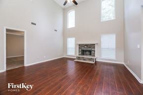 Middleburg house for rent - A large empty room with a fireplace and wooden floors.