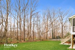 Clemmons house for rent - a backyard with trees and green grass and a house