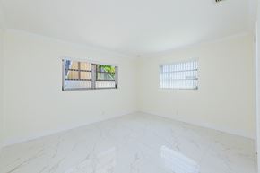 Hollywood apartment for rent - an empty room with two windows and a marble floor
