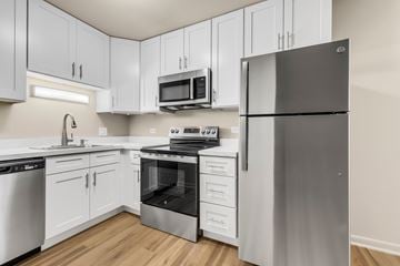 Villa Park apartment for rent - A kitchen with white cabinets and a stainless steel refrigerator.