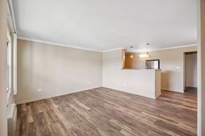 Evergreen Park apartment for rent - an empty living room with wood flooring and a kitchen