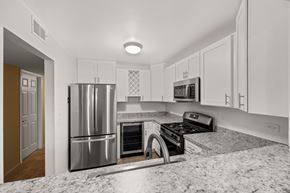 Downers Grove apartment for rent - A kitchen with a stainless steel refrigerator and a black stove top oven.