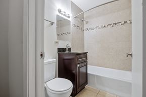 Lombard apartment for rent - A white toilet sits next to a brown cabinet in a bathroom.