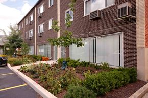 Lombard apartment for rent - A brick building with a parking lot in front.