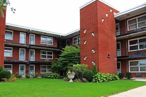 Oak Lawn apartment for rent - A red brick building with a green lawn in front.
