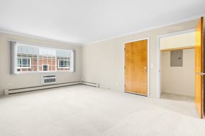 Naperville apartment for rent - A room with a window, a door, and a wall socket.
