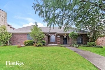 Mesquite house for rent - a brick house with a lawn and a sidewalk