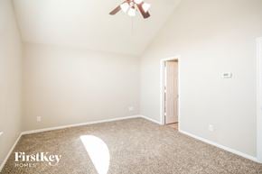 Houston house for rent - a bedroom with a ceiling fan and a carpeted floor