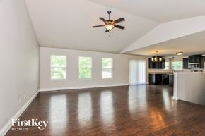 Wentzville house for rent - A spacious room with a ceiling fan and wooden flooring.
