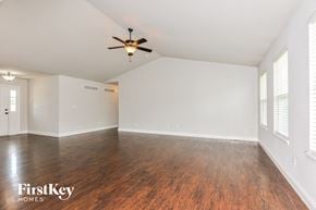 Wentzville house for rent - A spacious room with wooden flooring and a ceiling fan.