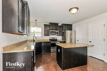 Wentzville house for rent - A kitchen with dark wood cabinets and a granite countertop.