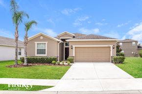 Davenport house for rent - a beige house with a garage and palm trees