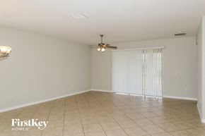 Davenport house for rent - an empty living room with white walls and a ceiling fan