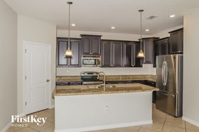 Davenport house for rent - a kitchen with granite counter tops and black cabinets and stainless steel appliances
