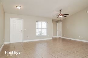 Lehigh Acres house for rent - A spacious room with a ceiling fan and tile flooring.