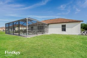 Lehigh Acres house for rent - A house with a white exterior and a glass enclosed patio area.