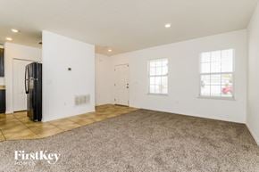 Poinciana house for rent - A spacious room with a carpeted floor and two windows.