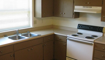 Moorhead house for rent - A kitchen with a white stove and brown cabinets.