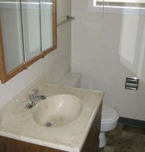 Moorhead house for rent - A bathroom with a sink, toilet and mirror.