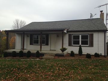 Bowerston apartment for rent - A house with a grey roof and white walls with a small front porch.