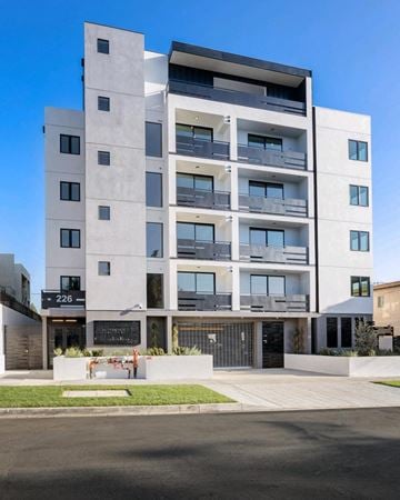 Los Angeles apartment for rent - A modern multi-story building with balconies and a black gate in front.