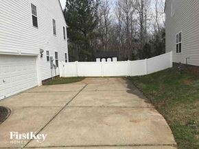 Huntersville house for rent - a white fence surrounds a driveway in front of a house
