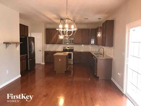 Huntersville house for rent - an empty kitchen with wooden floors and stainless steel appliances