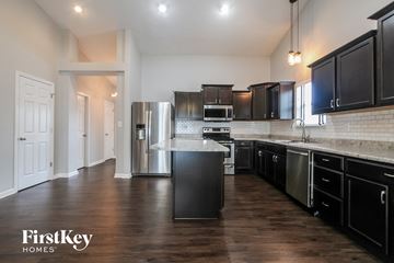 Shelbyville house for rent - a large kitchen with black cabinets and stainless steel appliances