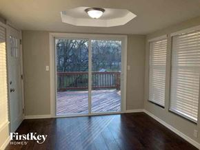 Independence house for rent - an empty living room with a sliding glass door to a deck