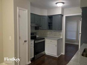 Independence house for rent - a small kitchen with black appliances and white cabinets