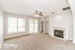 Orange Park house for rent - a living room with a fireplace and a ceiling fan