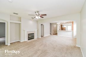 Orange Park house for rent - an empty living room with a ceiling fan and a fireplace