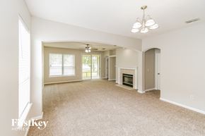 Orange Park house for rent - a spacious living room with a fireplace and carpeted flooring