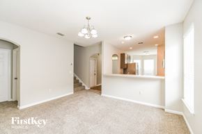 Orange Park house for rent - a spacious living room with white carpet and a kitchen